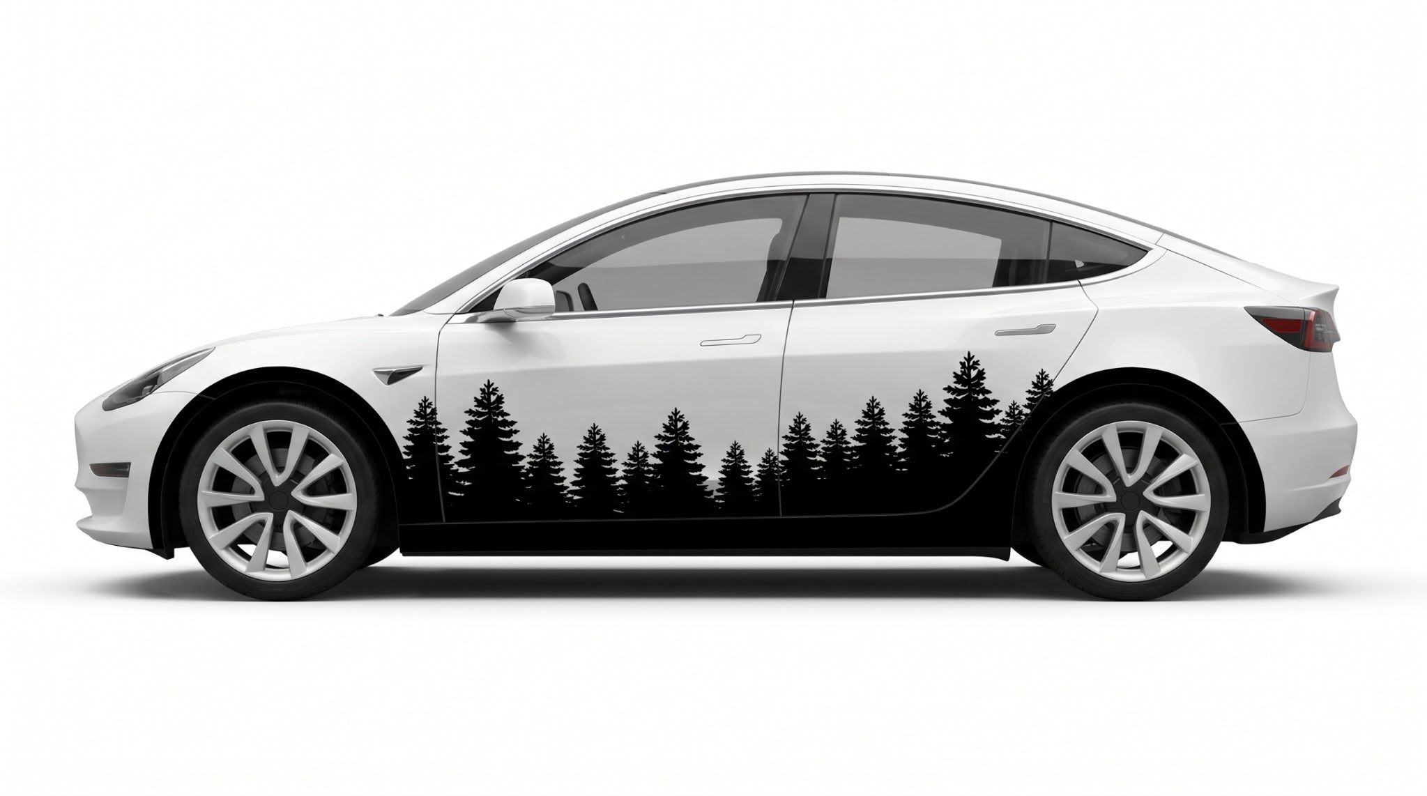 A white Tesla Model Y sedan shown in side profile on a light gray studio background, featuring a large black pine tree forest graphic printed along the lower side panel.